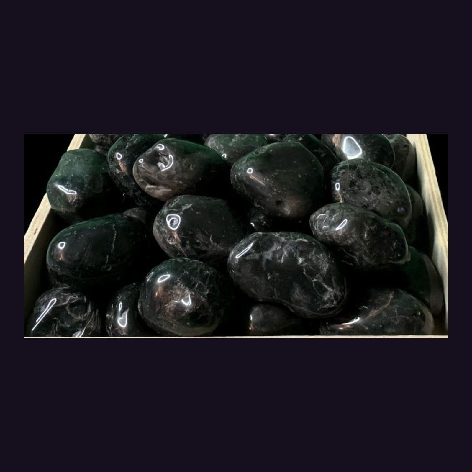 Tray of tumbled black onyx stones showing the polished finish and range of sizes in stock.