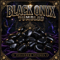 Tumbled black onyx stones, deeply polished jet black with glossy highlights along their edges.